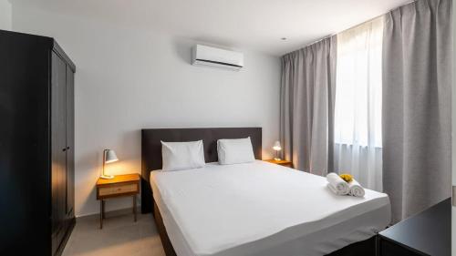 a bedroom with a large white bed and a window at Dushi Breeze in Blue Bay