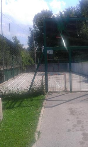 a tennis court with a fence and a tennis court at Guesthouse Ema in Banja Luka