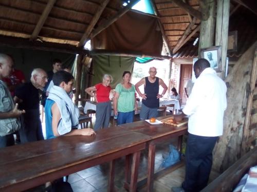 a group of people standing around a table at Malombo Selous Forest Camp in Kwangwazi