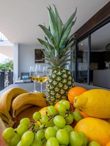 una pila di frutta su un tavolo con un ananas di Luxe Breeze a Blue Bay