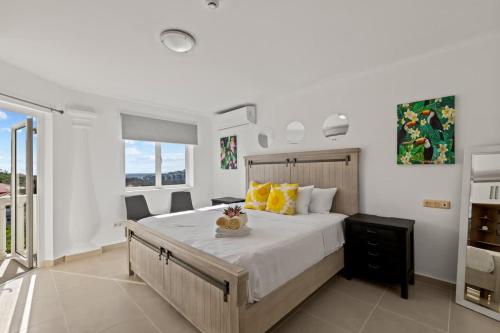 Un dormitorio con una cama grande con almohadas amarillas. en Little Dreams, en Dorp Sint Michiel