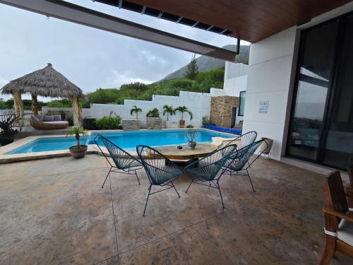 ChantepecにあるLa casita Blanca, it has everythingのテーブルと椅子とプールのあるパティオ