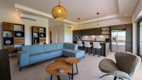 a living room with a blue couch and a kitchen at The Breeze 50 in Willemstad
