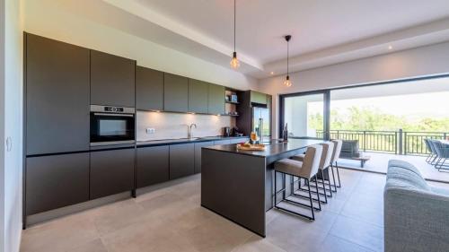 a kitchen with black cabinets and a bar with a view at The Breeze 50 in Willemstad