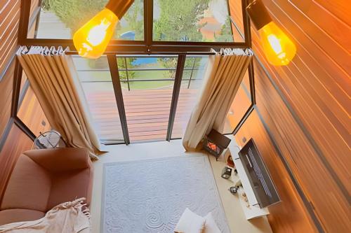 Cette suite dispose d'un salon avec une grande fenêtre. dans l'établissement Pousada Casa Florinda, à Teresópolis