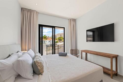 una camera da letto con un letto grande e una televisione di Azure Penthouse a Willemstad