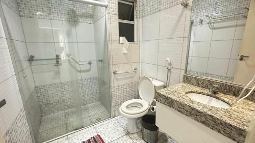 a bathroom with a shower and a toilet and a sink at Frente ao Parque da Lagoa Quente Entrada NÃO INCLUSA Aptos Particulares com varanda in Caldas Novas