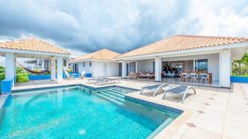 a villa with a swimming pool and a house at Villa Star Beach - Private pool and sea view! in Willemstad