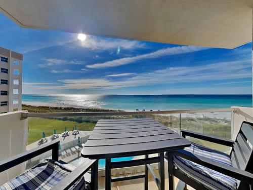 a table on a balcony with a view of the beach at Regency Towers #501 West in Pensacola Beach