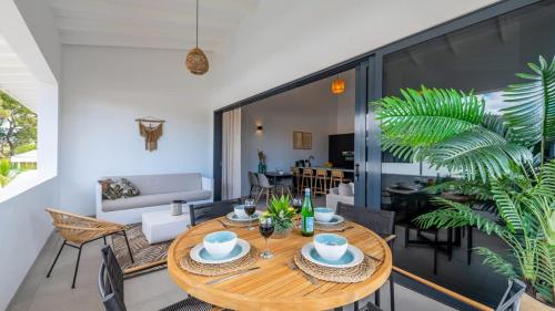 an open living room with a wooden table and chairs at The Wave - Excellently located Penthouse with pool in Jan Thiel