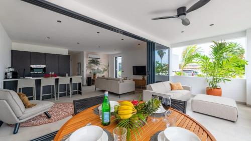 a living room with a table with fruit on it at Palm Suite - Newly constructed poolside apartment just minutes from the beach in Jan Thiel