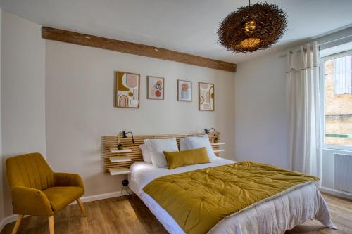 Salignac EyviguesMaison T3 tout confort et spa Le Clos des Pierres的带床和椅子的卧室