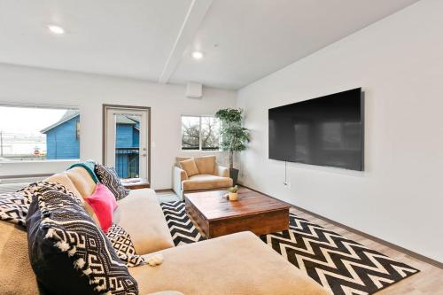 a living room with a couch and a flat screen tv at HUGE-Fun-Trendy Apt by Perry District & Downtown in Spokane