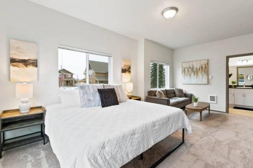 a white bedroom with a bed and a couch at HUGE-Fun-Trendy Apt by Perry District & Downtown in Spokane
