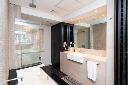 une salle de bain avec un lavabo et un miroir dans l'établissement Heritage-Chic Apartment in Cape Town, au Cap