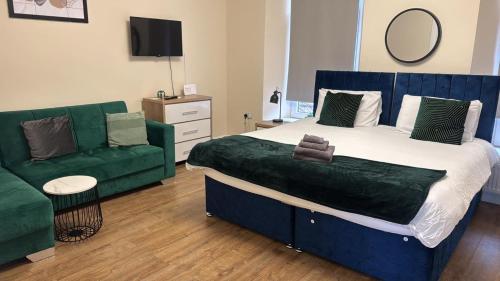 1 dormitorio con 1 cama grande y 1 sofá verde en Apartment 3- 216 high Street, en Arbroath