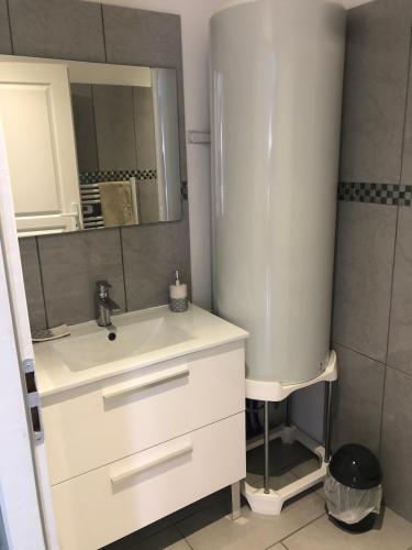 a white bathroom with a sink and a mirror at petite maison calme in Hourtin