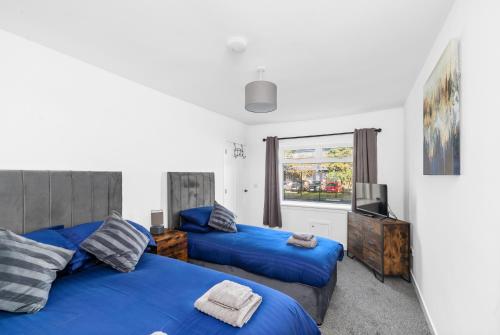 a bedroom with two blue beds and a window at Spacious and Peaceful 4BR 2Bathroom Near Montrose Port in Ferryden