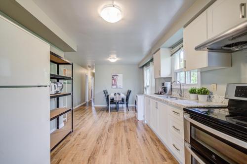 a large kitchen with white cabinets and a table at Nest in the Orchard--cozy room in Toronto
