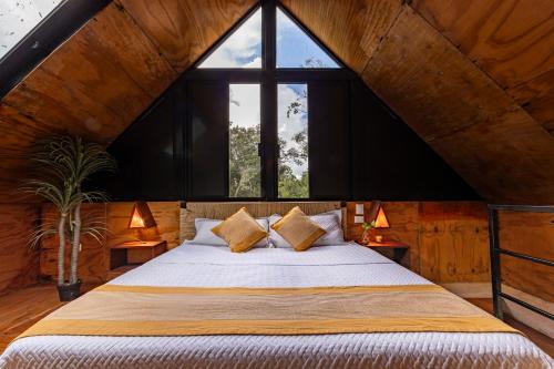 a bedroom with a bed with a large window at Xtambaa Selva in Tulum
