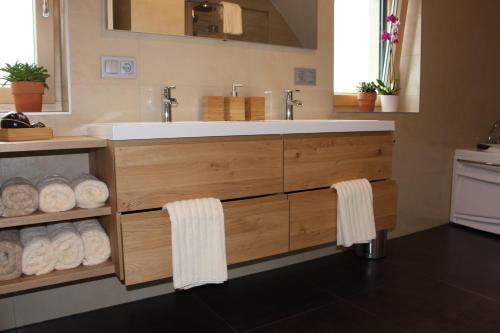 a bathroom with a vanity with a sink and towels at Weingartenhaus in Leutschach