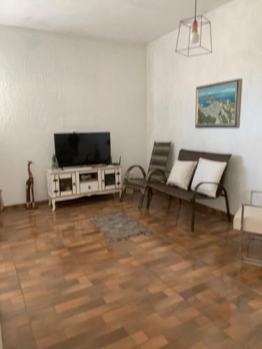 ein Wohnzimmer mit einem TV und einem Sofa in der Unterkunft Cruzeiro in São Pedro da Aldeia