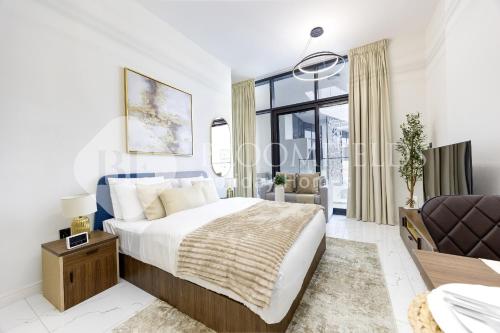 Un dormitorio blanco con una cama y una silla. en Bloomfields Elegant Pool View Stu The Gate, en Abu Dhabi Intl