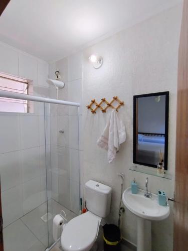 a bathroom with a toilet and a sink and a shower at Terral Casa de Praia in Guarujá