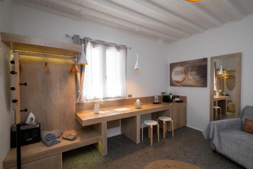 a room with a desk with a window and a couch at Mykonos Double Luxury Mini Suites-With External Hot spa Adults only in Ano Mera