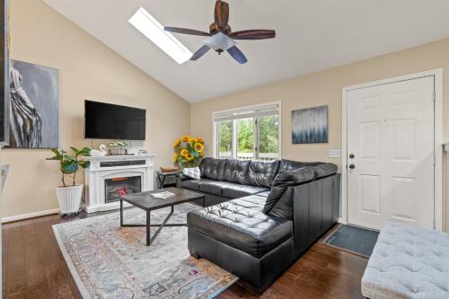 a living room with a leather couch and a ceiling fan at Cozy Mountain Song- Massanutten Mountain in McGaheysville