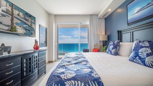 a bedroom with a bed with a view of the ocean at Encantame Towers Verano 1401 in Playa Encanto
