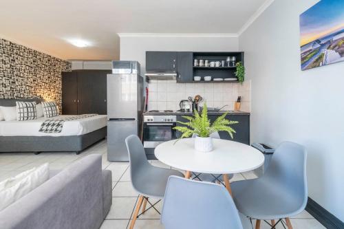 a kitchen and living room with a table and chairs at City Oasis Suite Cape Town in Cape Town