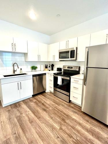 a kitchen with white cabinets and a stainless steel refrigerator at Beehive Escape -Salt Lake City in Salt Lake City