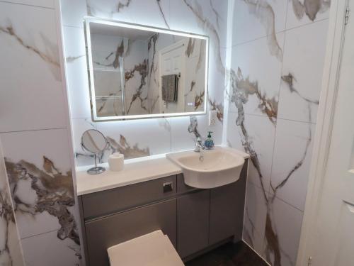 a bathroom with a sink and a mirror at Nobles Nook in Seahouses