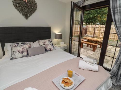 a bedroom with a bed with a tray of bread on it at Nobles Nook in Seahouses
