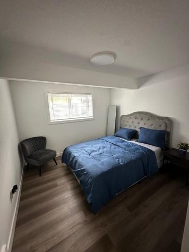a bedroom with a blue bed and a chair at Guest Suite with Private Entry in Calgary in Calgary