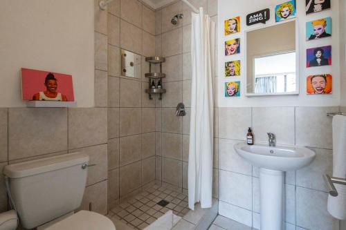 a bathroom with a shower and a toilet and a sink at City Light & Mountain Sight in Cape Town