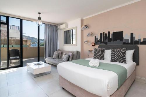 a bedroom with a large bed and a couch at City Light & Mountain Sight in Cape Town