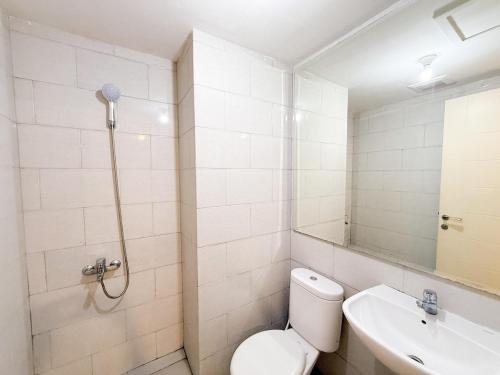 a white bathroom with a toilet and a sink at La Vida II at Anderson Tower in Surabaya