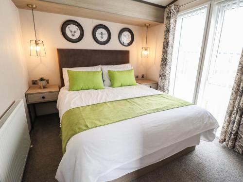 a bedroom with a large bed with two clocks on the wall at Heather William Lodge in Woodhall Spa