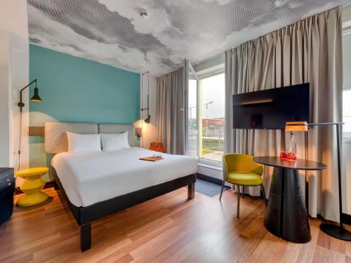 a hotel room with a bed and a table at ibis Berlin Kurfuerstendamm - neu renoviert in Berlin