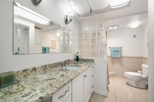 une salle de bains avec lavabo, toilettes et miroir dans l'établissement 2 Bedroom Beachfront Condo on Clearwater Beach, à Clearwater Beach