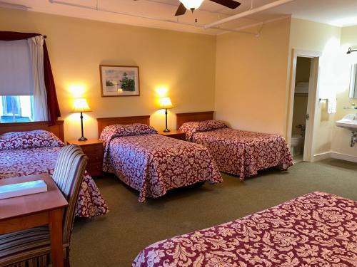 une chambre d'hôtel avec trois lits dans une chambre dans l'établissement Silver Bay YMCA Inn and Conference Center, à Silver Bay