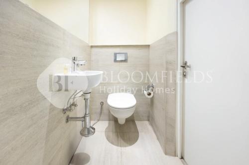 Un baño con un inodoro blanco y un lavabo. en Bloomfields Elegance 1br in Oasis Masdar, en Abu Dabi