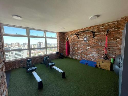 a gym with chairs and a brick wall at Departamento studio nuevo en Concepcion in Concepción