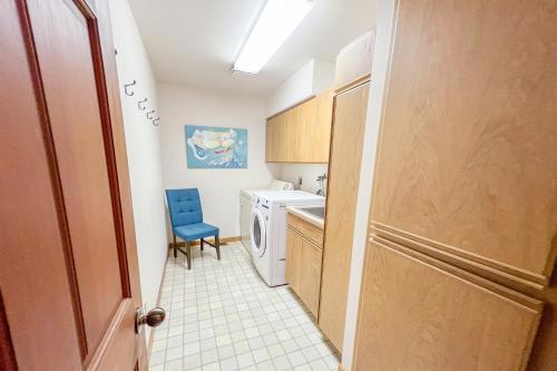 a bathroom with a washing machine and a blue chair at Hot Tub & Game Room in Large Ocean Front Home! Second Story in Holiday Beach