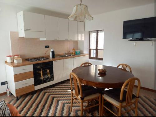 Una cocina con una mesa de madera y una mesa y sillas. en Cà Giaculn, 