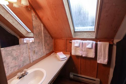 a bathroom with a sink and a window and towels at Cute Cabin in Yachats! Short walk to rivers' edge! River Walk Cabin in Yachats