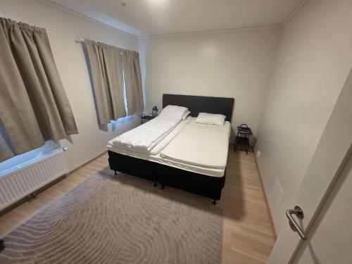 a bedroom with a bed with white sheets and a rug at Nice apartment in the center of Trysil 402 in Trysil