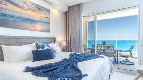 a bedroom with a bed and a view of the ocean at Encantame Towers Viento 1002 in Playa Encanto